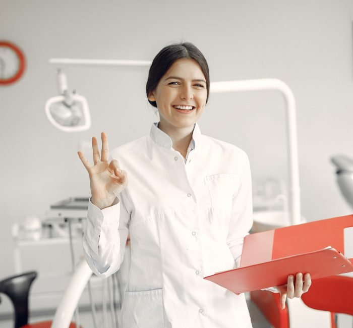 Beautiful dentist working on a dental clinic Woman in a uniform. Doctor working at the clinic. Dentist holds a folder in her hands